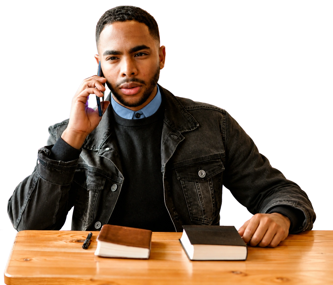 Un homme échange au téléphone, assis à son bureau.